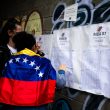 Dos personas buscan sus plazas de votación durante las elecciones del 28 de julio en Venezuela.