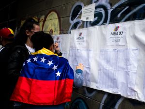 Dos personas buscan sus plazas de votación durante las elecciones del 28 de julio en Venezuela.